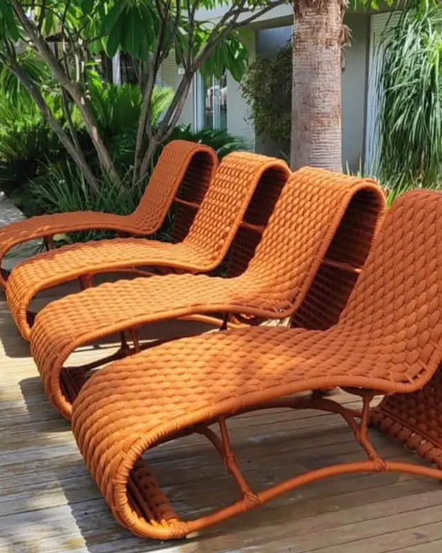Espreguiçadeiras em fibra trançada laranja na área de piscina
